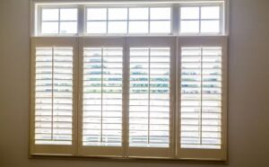 White plantation shutters framing a sunny Madisonville, LA living room.